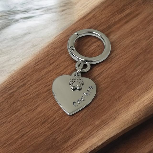 Placa de identificação de pet em formato de coração com nome Cookie e patinha